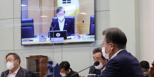 문재인 대통령이 16일 오후 청와대에서 화상회의 형식으로 열린 국토교통부 2021년 업무보고에서 변창흠 국토교통부장관의 보고를 받고 있다. <연합뉴스>